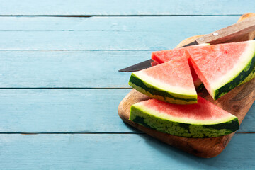 Fresh watermelon slices on blue wooden table. Copy space