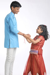 Indian brother and sister celebrating raksha bandhan festival at home.