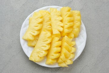 Fresh slices pineapple served in white plate

