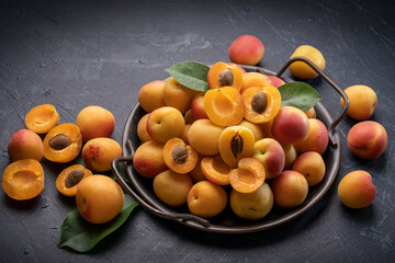 Fresh Apricot fruit with leaf on wooden background, Yellow Apricot on black plate over wooden...