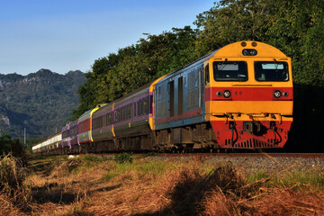 Naklejka premium Passenger train by diesel locomotive on the railway in Thailand
