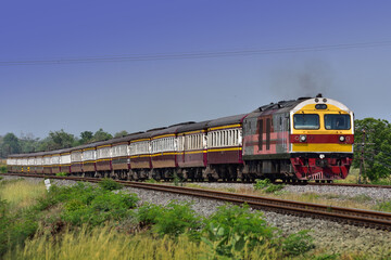 Passenger train by diesel locomotive on the railway in Thailand