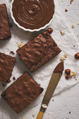 Delicious homemade chocolate brownie served with hazelnuts and melted cream