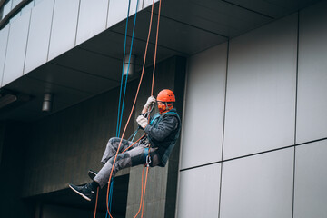 Industrial climber in uniform and helmet rises