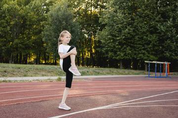 Obraz premium Child girl doing warm-up exercises before running