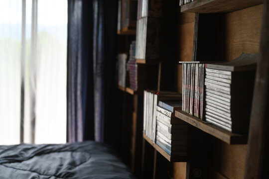 Wooden bookshelves filled with books in comfortable bedroom