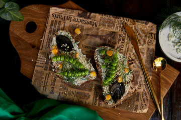 Homemade natural healthy sandwich with peas, basil, corn on greased cheese. Healthy natural food with cutlery