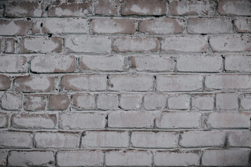 An old brick wall with remnants of white paint. Background