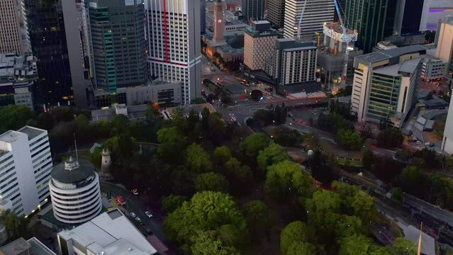 Fly Over Lush Trees On City Park Towards King George Square During Sunrise In Brisbane CBD, Queensland, Australia. Aerial Drone Shot