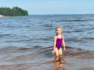 Little girl running with splashes in sea