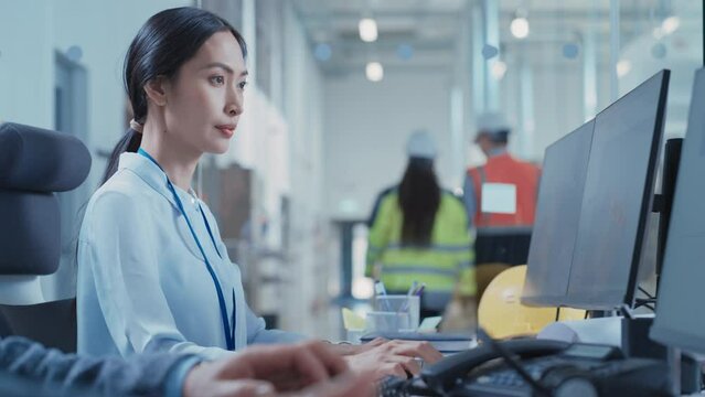 Portrait of an Asian Industrial Engineer Drafting Blueprint of a Heavy Industry Machine Parts on Computer CAD Software in a Factory. Modern Technological Research and Development Center. Arc Shot.