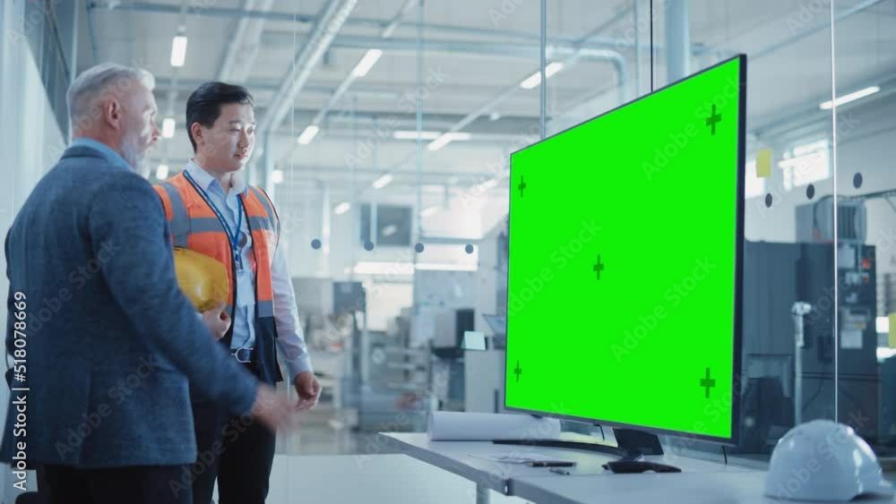 Poster factory office meeting: senior manager talking with engineer in a conference room with tv with green