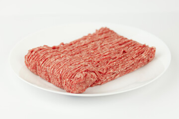 Ground meat on a white plate, minced beef for cooking.