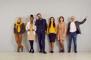 Teamwork and partnership. Portrait of diverse, friendly and successful business team standing in row on wall background. Men and women of all ages and nationalities work together on business projects.