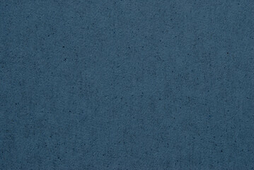 A sheet of dark blue ecycled paper or cardboard texture as background