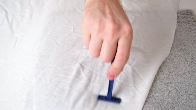 A man removes fabric pills using a disposable shaving machine. A razor for removing pellets.