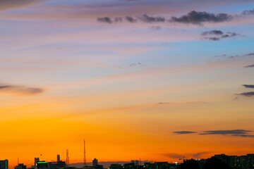 Gives a warm feeling, sunset behind the city building, silhouette city ​​tall buildings, building silhouette again beautiful sky background and freedom concept.