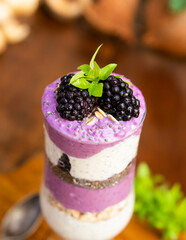 Blackberry smoothies with chia seeds in glass with fresh berries and mint on wooden table