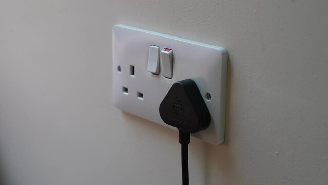 White Uk plug sockets being turned on to power a plug