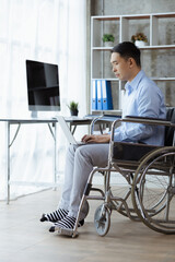 Man sitting on a wheelchair, man with a wheelchair at company office, Working together as a team in a large organization. The concept of team management is diverse.
