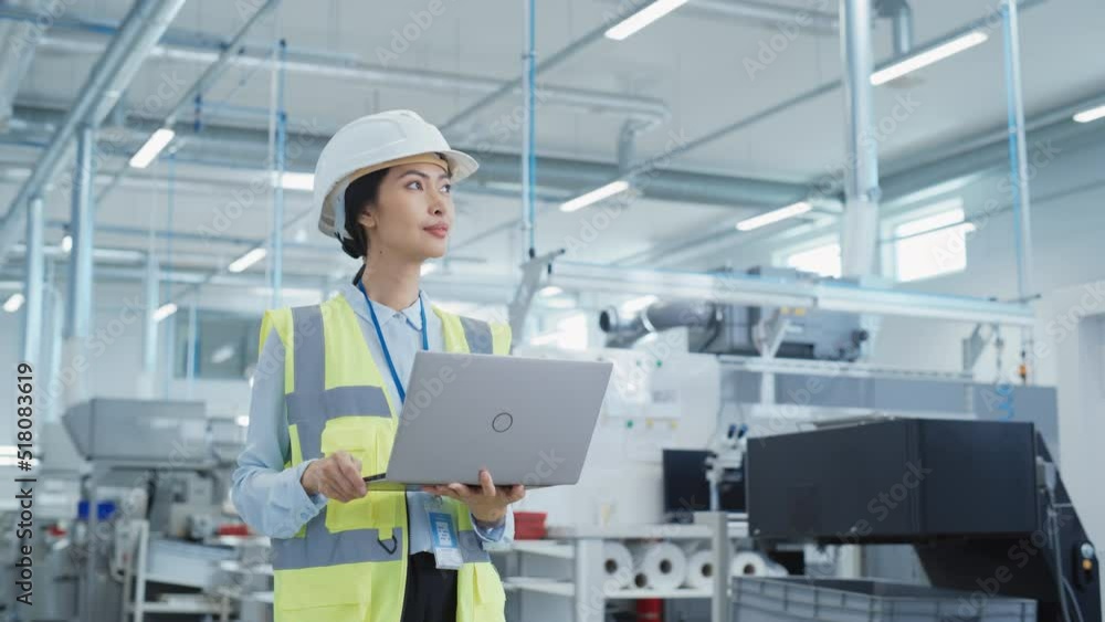 Aufkleber portrait of an asian female engineer in hard hat standing and using laptop computer at electronic ma