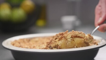 The cook serving fresh baked Apple Crumble, slow motion.