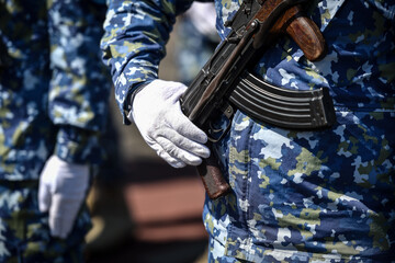 Soldiers in blue camouflage uniforms are seen in formation during military ceremony.
