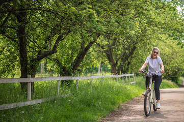Obraz premium A mid aged woman riding a bike in a park
