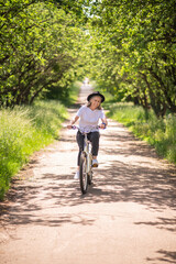A cheerful mature woman on a bike in the park