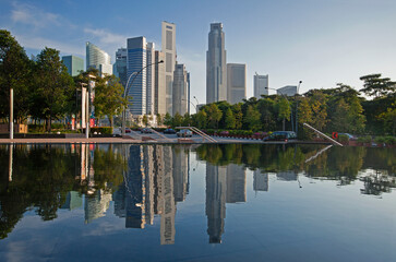 Fototapeta na wymiar Financial district and skyscrapers of Marina Bay reflected in Pool at the Esplanade at sunset