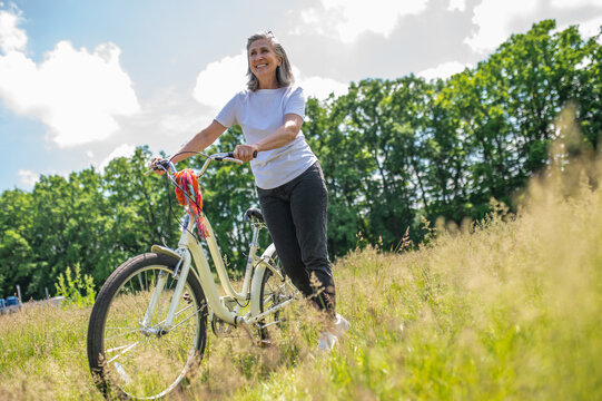 A woman with a bike in the meadow
