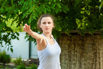 Young woman practices yoga in the summer garden: Natarajasana, Lord of the Dance Pose or Dancer Pose