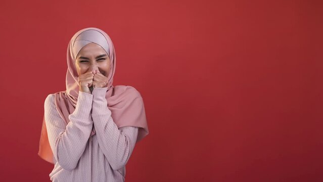 Amazed woman. Wow face. Advertising background. Surprised excited female in hijab shocked with unbelievable offer isolated on red empty space.