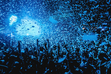 crowd of people dancing with confetti