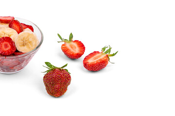 Fresh strawberries, a plate with sliced strawberries and a banana, on a white background close-up