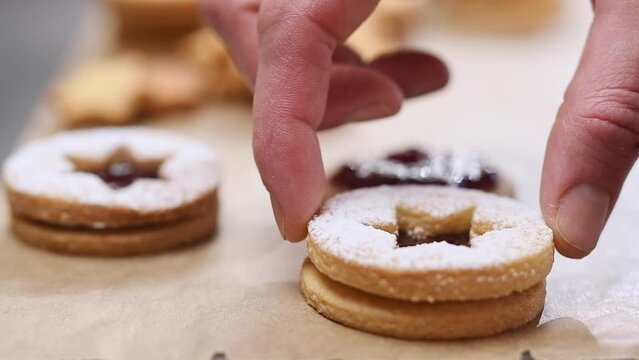 Chef prepares almond cookies with jam.
