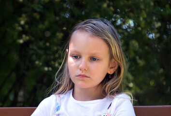portrait of a sad pensive little girl 7 years old with long blond hair