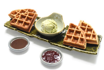 Homemade ice cream with waffle on plate with chocolate syrup and marmalade