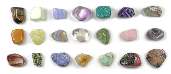 21 different types of healing stones - in three neat rows randomly placed on a white background...