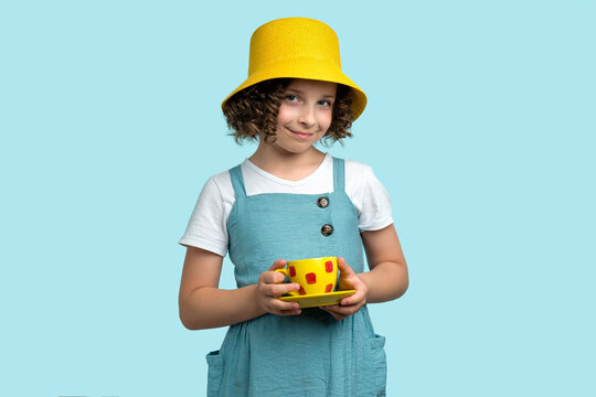 Girl drinks tea from yellow cup
