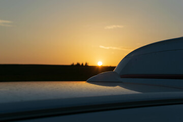 Fototapeta na wymiar Sunset on the roof of the car
