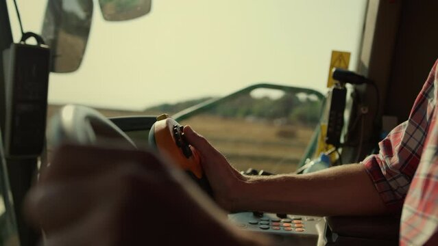 Farmer hands driving harvester closeup. Tractor operator controlling machinery