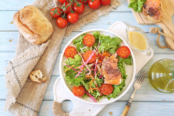 Healthy food. Lettuce salad with red fish, raw vegetables and olive oil. Red fish sandwich with rye bread, poppy seeds and mustard sauce