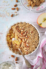 Fresh apple crumble from oatmeal, almondes dressing on light background