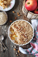 Fresh apple crumble from oatmeal, almondes dressing on wooden background