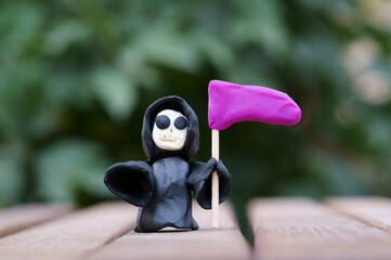 Figure of death with a scythe close-up.