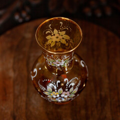 antique orange glass vase with flower pattern in luxury interior. hand-painted crystal vase