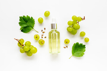 Bottle of grape seed oil with green grapes. Eco cosmetic product