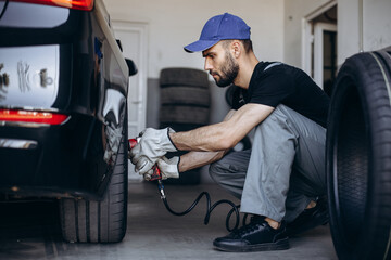 Repairman at car service changing tires