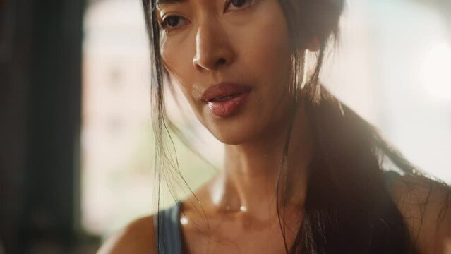 Strong Asian Female Wipes Sweat from Forehead, Looks at Camera. Successful Empowered Woman Fighting and Winning fight Against Injustices, Prejudices. Cinematic Stylish Sensual Close-up Portrait